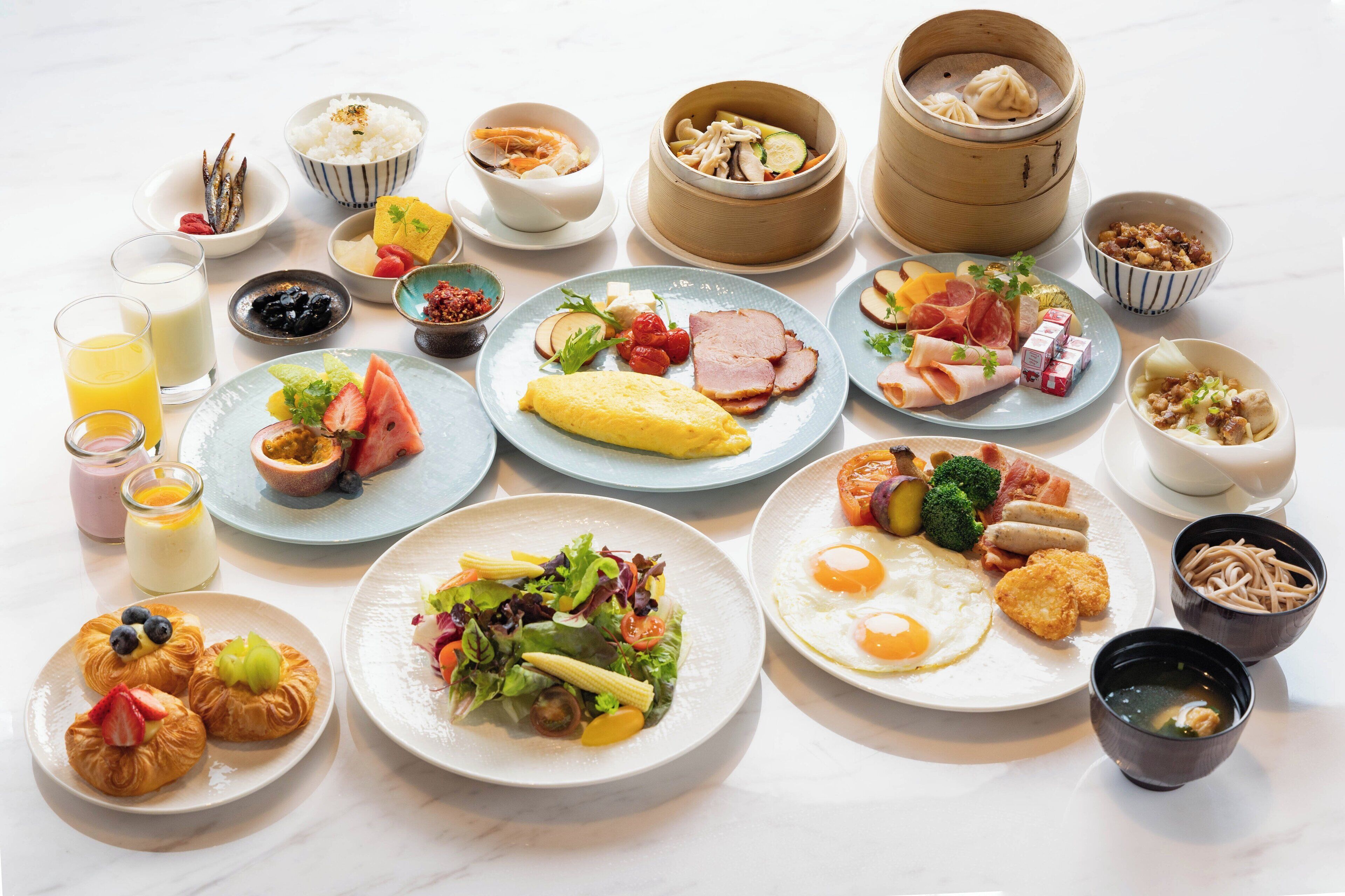 A variety of breakfast dishes including eggs, ham, and pastries.