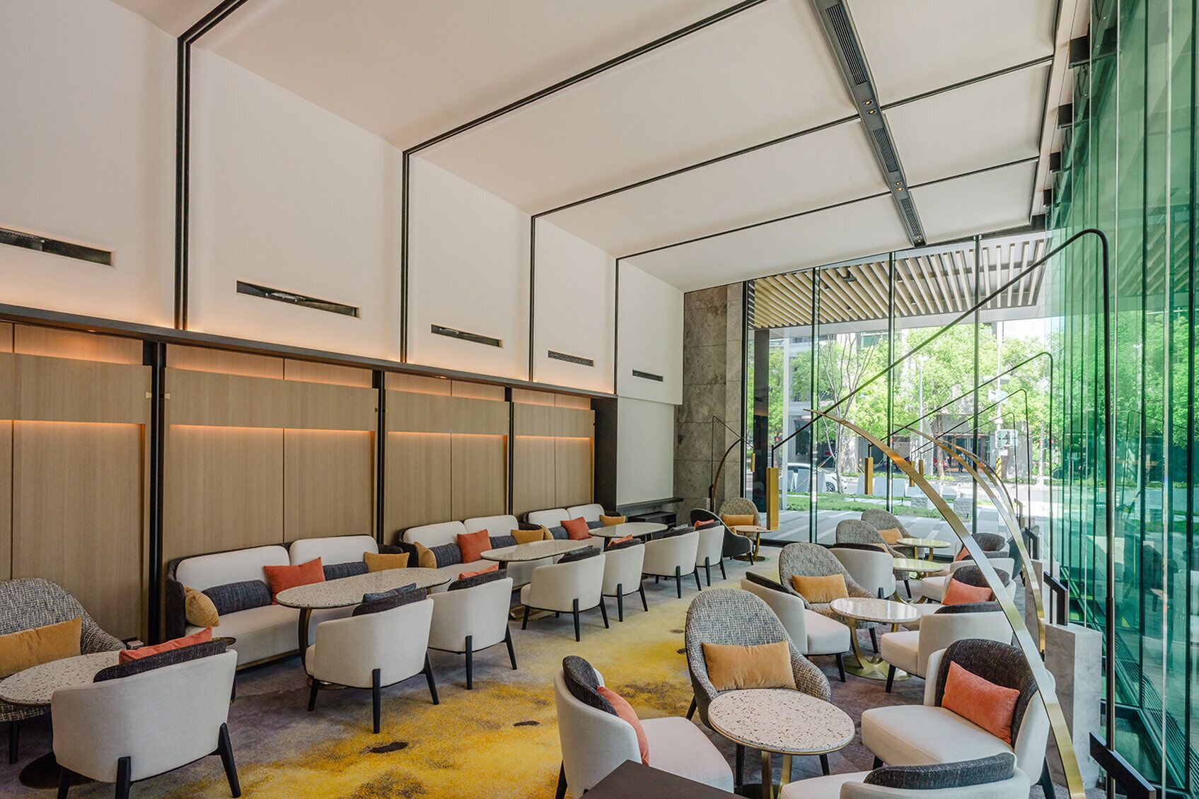 A modern interior with seating areas, tables, and a staircase leading outside.