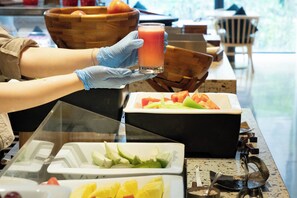 Ein reichhaltiges Buffet mit verschiedenen Früchten und einem Glas Saft.