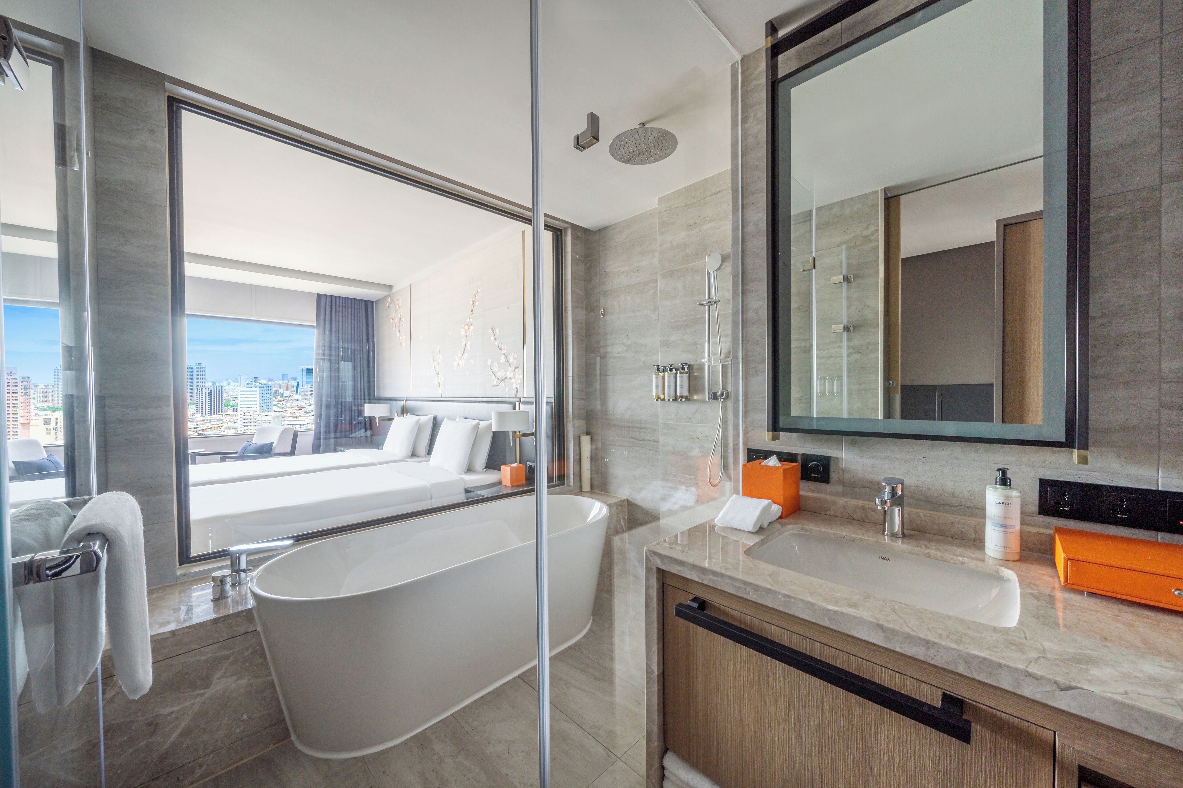 A modern bathroom with a freestanding bathtub, a large mirror, and a vanity with a sink and countertop.