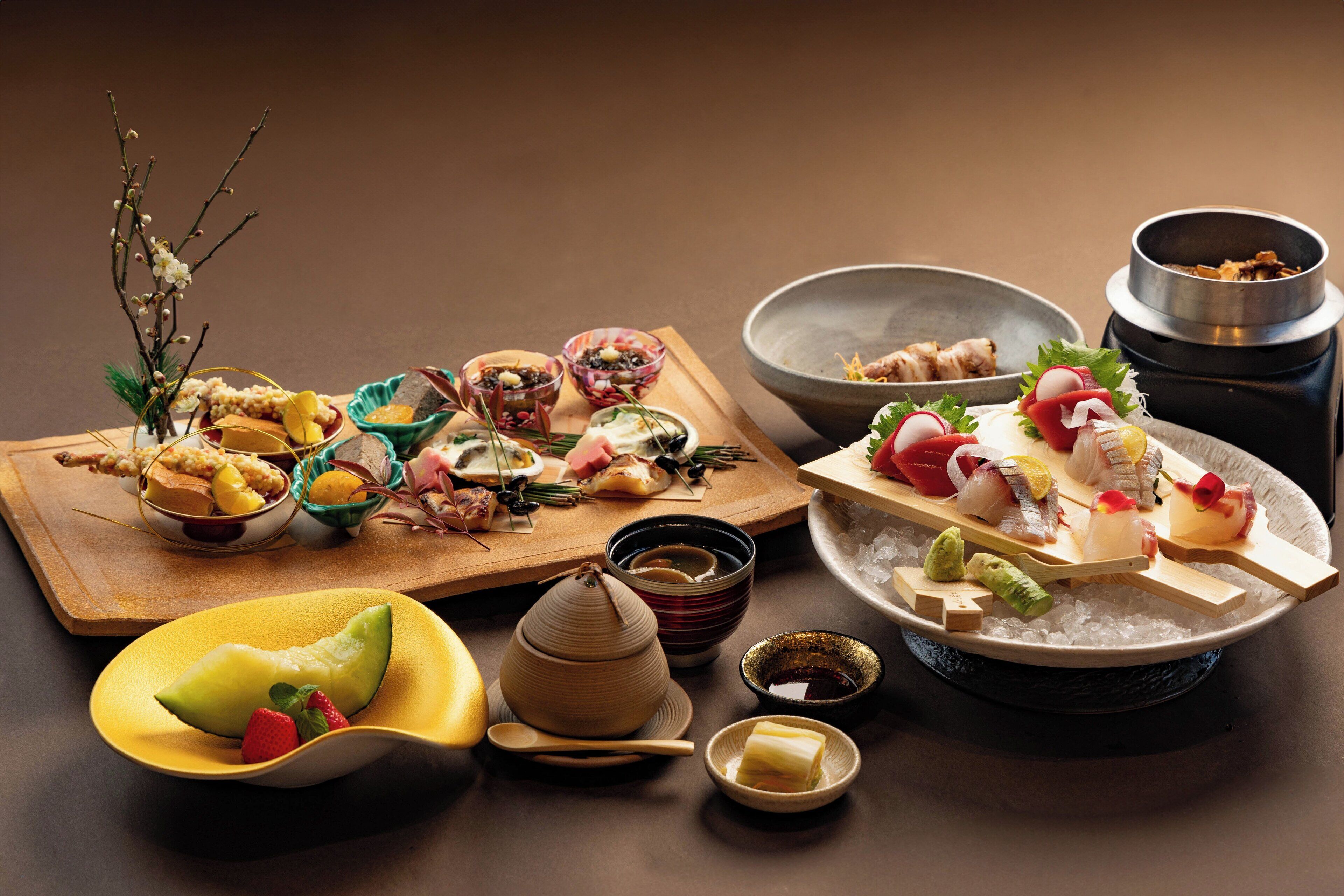 A variety of food items on a wooden board, including fruits, vegetables, and small dishes.