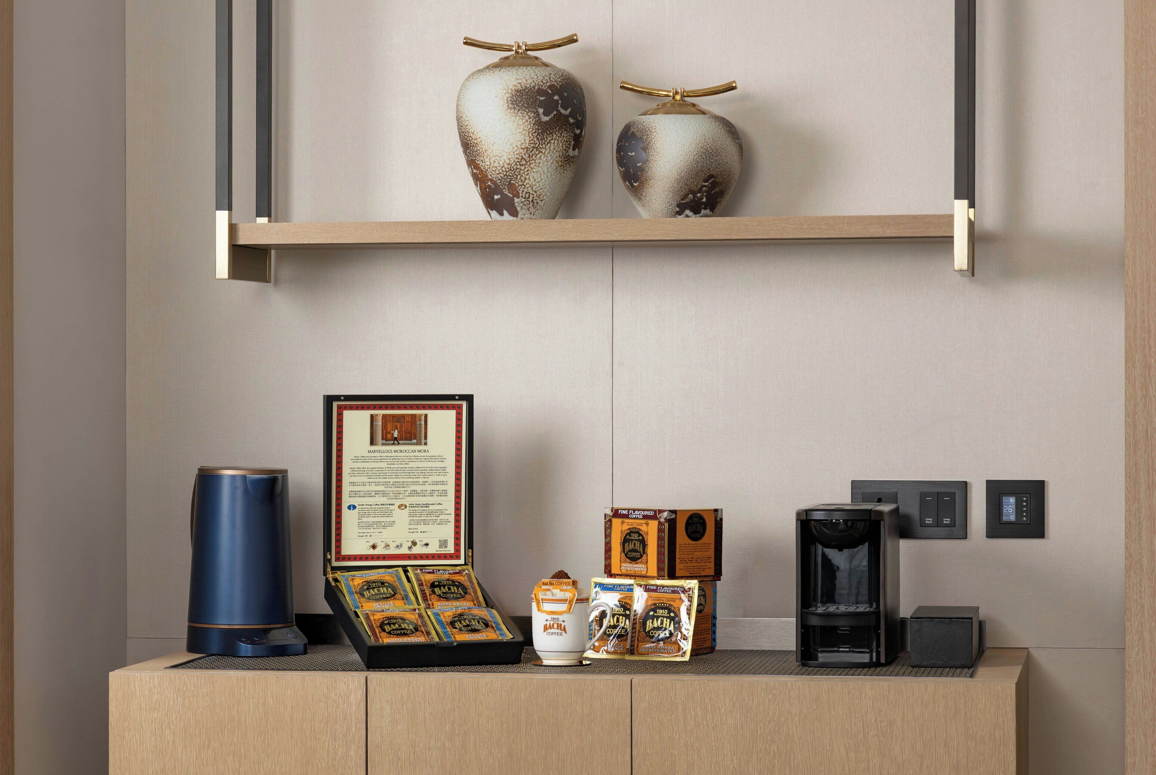 A coffee station with a coffee maker, a framed certificate, and coffee pods on a wooden counter.