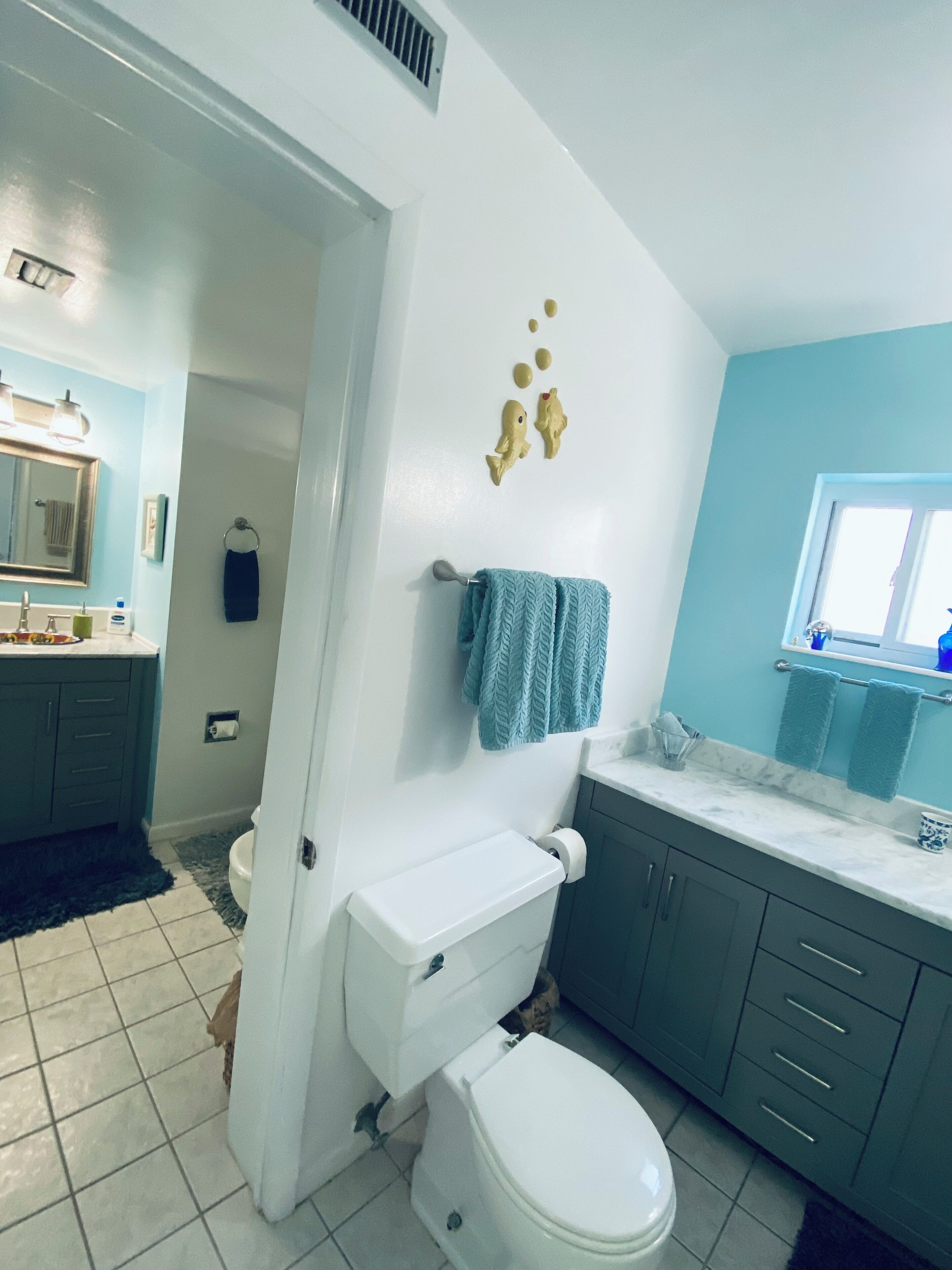 Une salle de bain avec des toilettes, un lavabo et des placards.