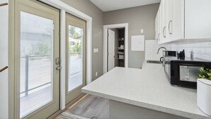 A kitchen with white cabinets, a microwave, and a countertop.