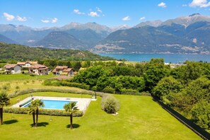 A residential area with a swimming pool, houses, and mountains in the background.