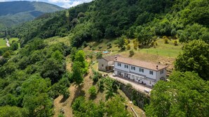 A hillside villa with a terracotta roof, surrounded by lush greenery and a clear blue sky. - Olimpia by Interhome (Borgo San Lorenzo)