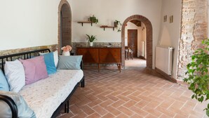 A cozy room with a sofa, a wooden cabinet, and a dining area. - Olimpia by Interhome (Borgo San Lorenzo)