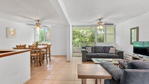 Amplia sala de estar con mesa de comedor, sofás y televisor.