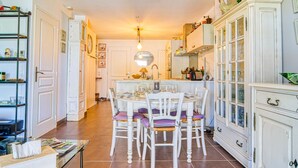 A kitchen with a dining table, chairs, and a cabinet. - Villa Les Genêts by Interhome (Montauroux)