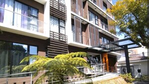 A modern multi-story building with balconies and large windows.