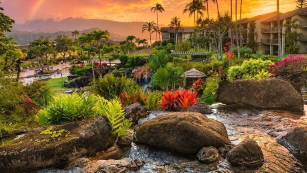 A resort with a pool, palm trees, and a waterfall. - Sunset Hideaway with Beach Access, Pools & AC (Princeville)