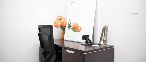 A small office space with a desk, chair, and a mirror.