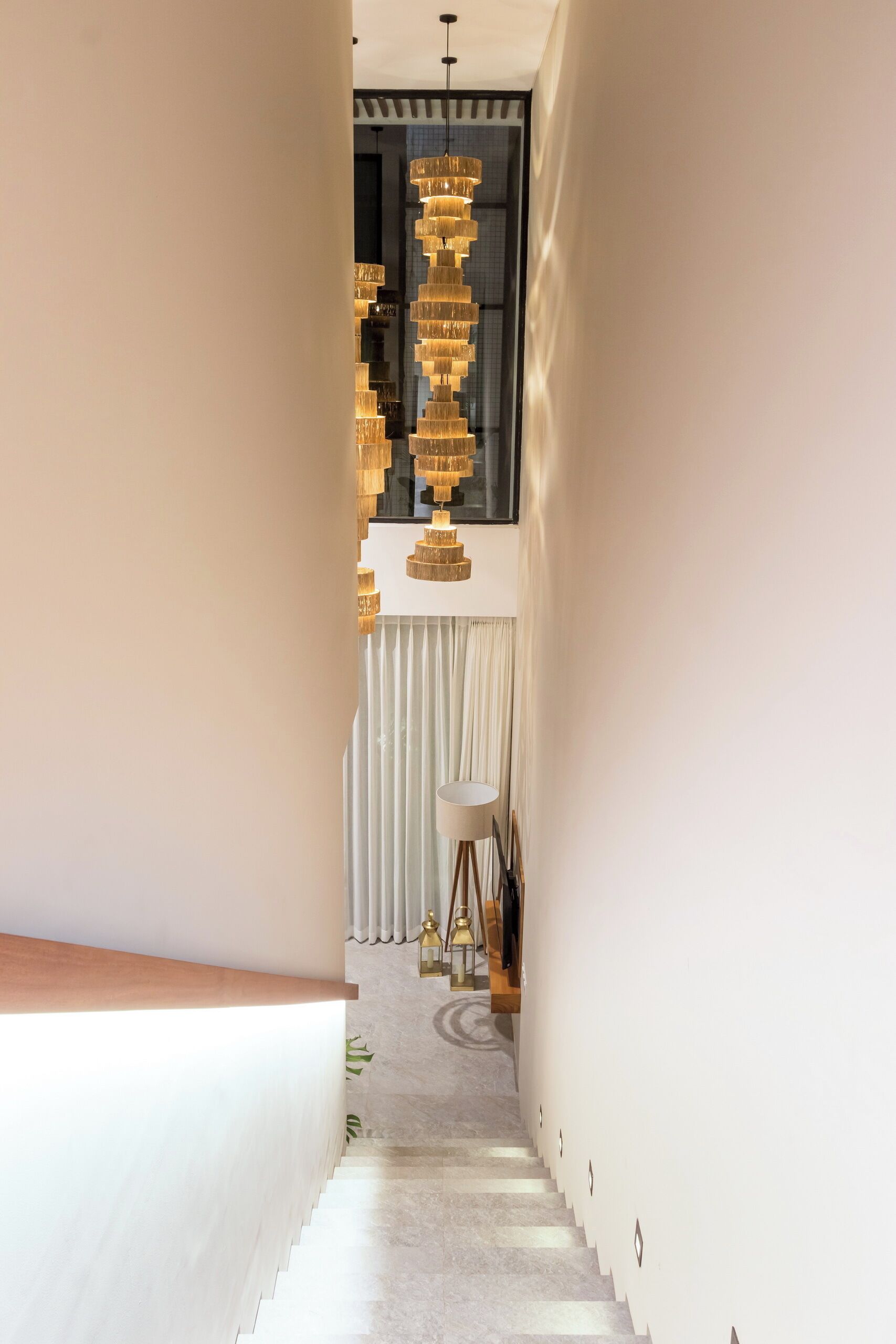 Gradi amb un llumeria modern i vista d'una habitació amb un gran finestral.