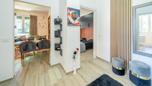 A modern living room with a sofa, chairs, a coffee table, and a decorative wall shelf.