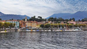 A waterfront town with colorful buildings, a clock tower, and boats docked along the shore.