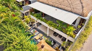 Un espacio al aire libre con varios niveles, piscina, asientos y abundante vegetación.