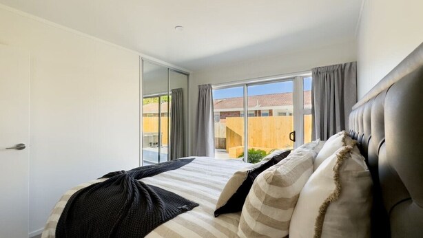 A bedroom with a bed, a window, and a view of the outside. - Tranquil Retreat in Red Beach (Red Beach)