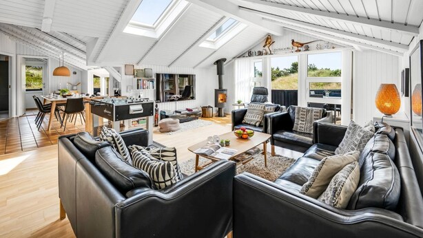 A spacious loft with high ceilings, skylights, a cozy seating area, a dining space, and a fireplace.