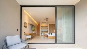 A modern room with a glass door leading to a kitchen and dining area. - Amaranto Hotel Boutique (Bacalar)