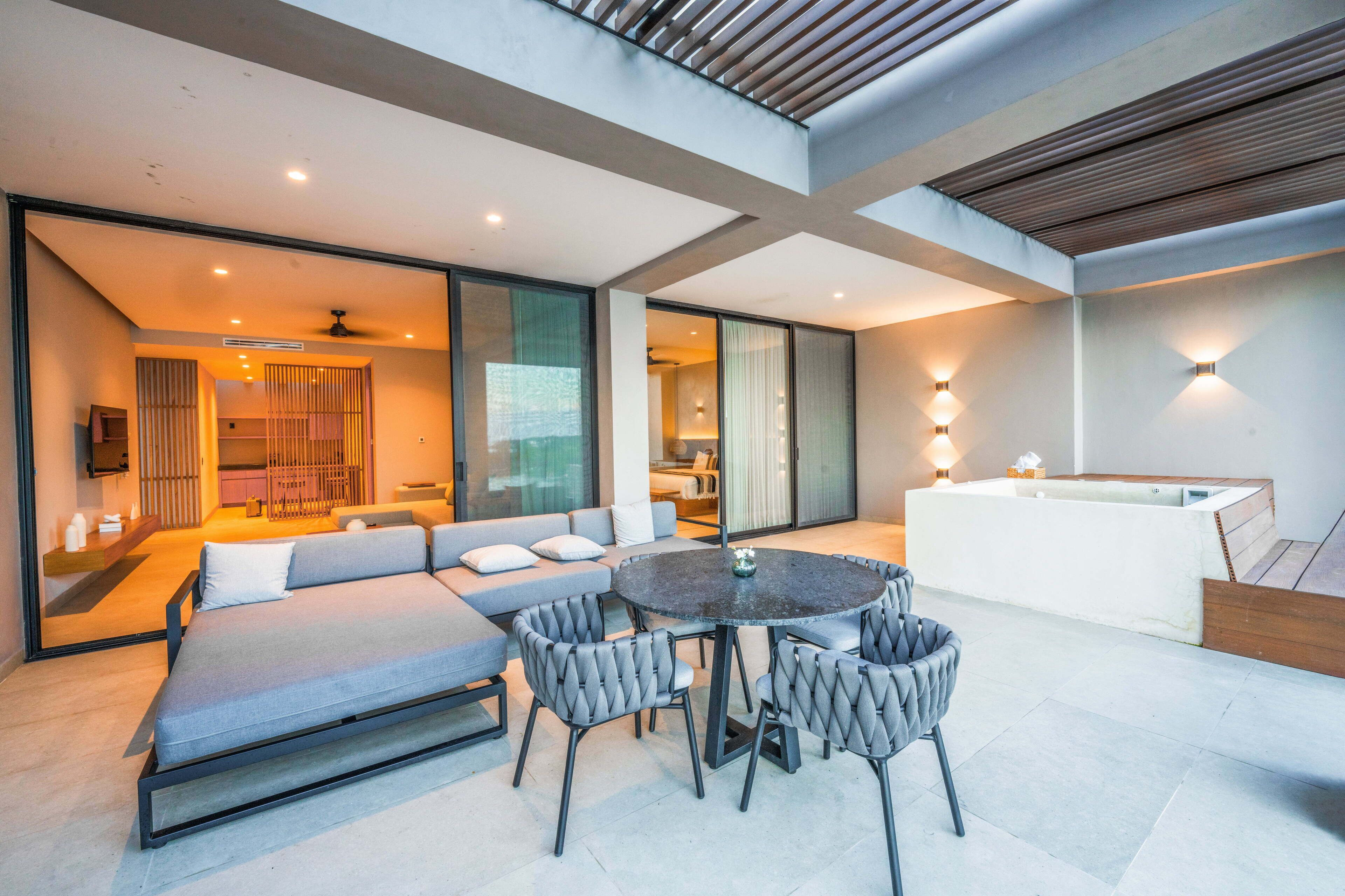 Een moderne zithoek met een bank, een ronde tafel en stoelen.