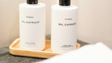 Två vita flaskor av BYREDO BAL D'AFRIQUE på ett träbricka.