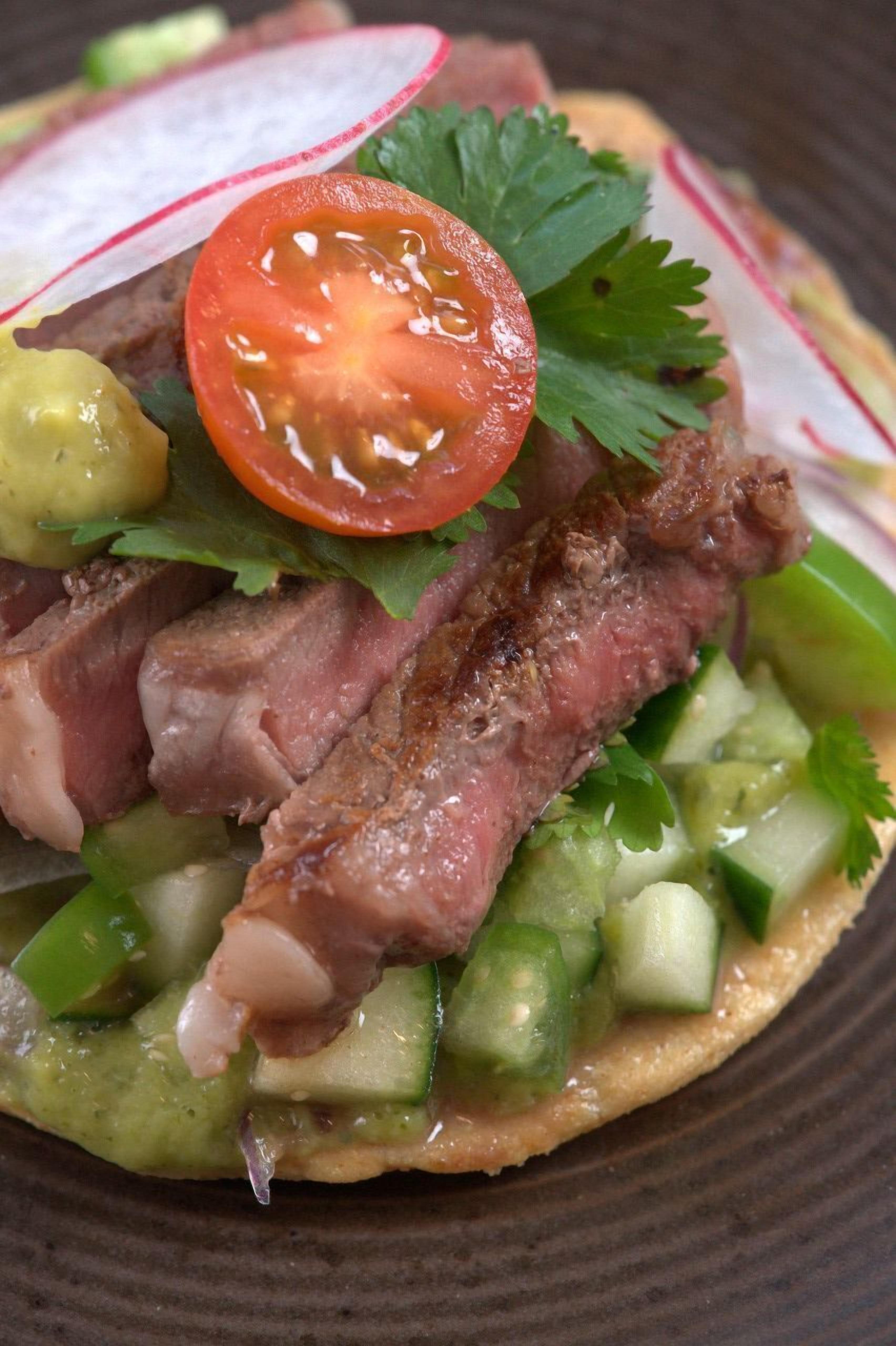 Un plato con carne en rodajas, verduras y una guarnición.