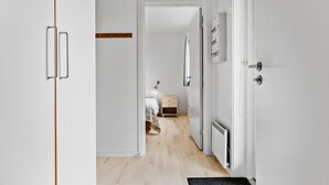 A hallway with a bed, a nightstand, and a radiator.