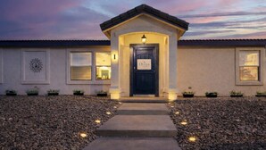 A building with a dark entrance door, a small porch, and a pathway leading to the door. - Big house w custom murals/2 Kings/Fun backyard w Games/Grill/Dog OK/Boat parking (Page)