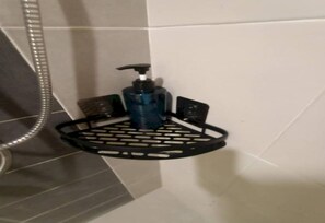 A bathroom with a black soap dispenser on a black tray stand.