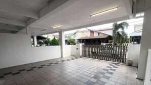 A spacious indoor area with tiled flooring, a gated entrance, and a view of residential buildings in the background. - SPOT ON 91018 Sunshine Bnb Concept Service (Ipoh)
