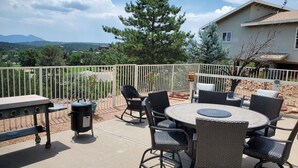 An outdoor patio with a round table and chairs, a grill, and a trash can. - Completely Remodeled and Modernized Smart Home in Payson (Payson)