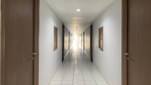 Un pasillo largo y estrecho con puertas a ambos lados, que conduce a habitaciones.