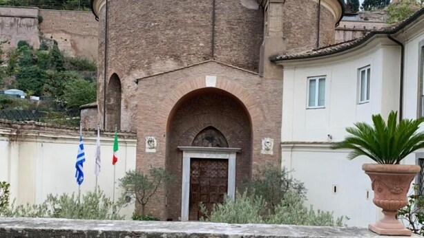 A building with a brick facade, a central arched entrance, and a small bell tower. - Suites in Rome 2 - Appartament (Roma)