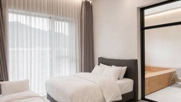 Un dormitorio moderno con cama, cortinas y un ventanal grande.