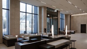 A modern hotel lobby with large windows, seating areas, and a reception desk. - Daegu Suseong The Arco Hotel Lions Park (Daegu)