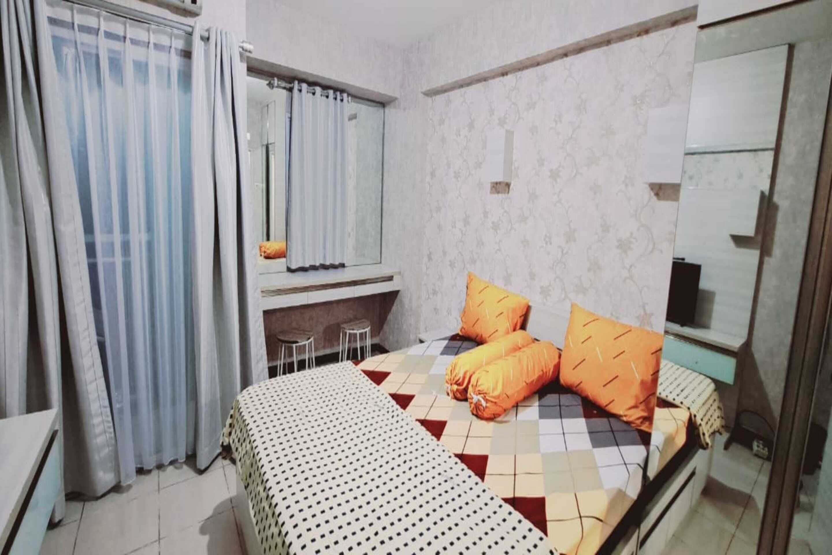 Un dormitorio con cama, escritorio y espejo.