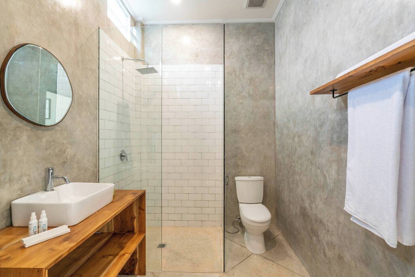 Een badkamer met douche, toilet en wastafel.