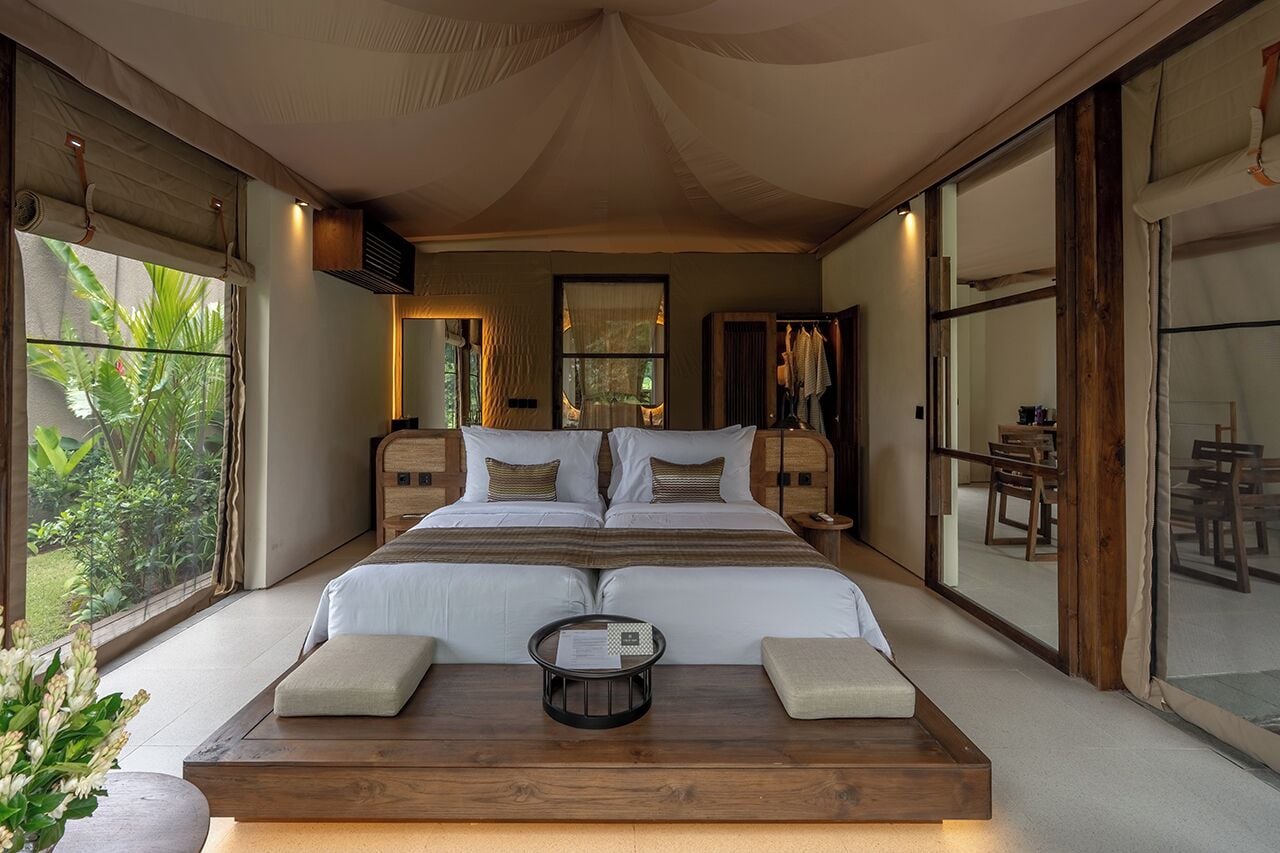 A spacious bedroom with a large bed, bedside tables, and a view of the garden.