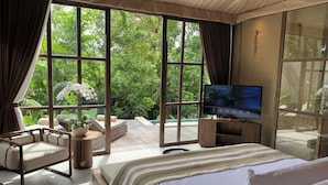 A bedroom with a large window, a bed, a TV, and a seating area with a plant. - Ubud Mas Glamping Luxury Tent (Mas)