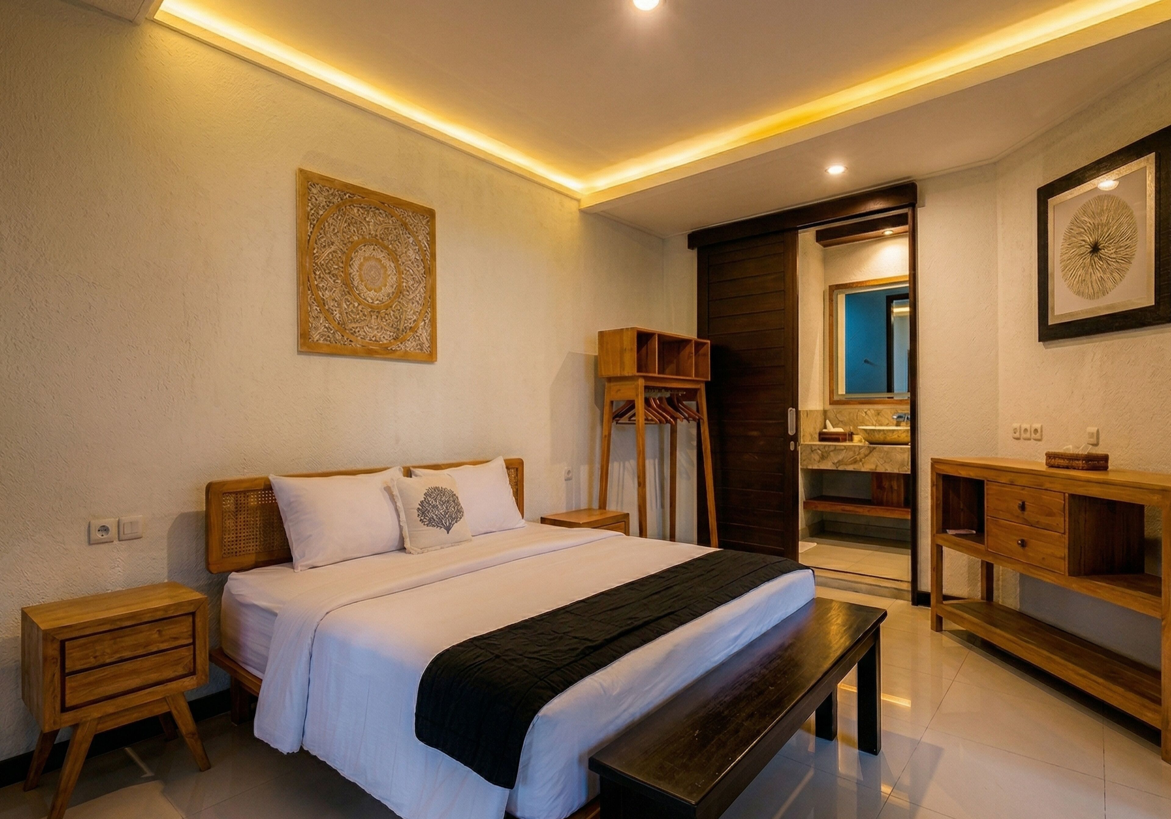 A bedroom with a bed, bedside tables, a bench, a wardrobe, and a mirror.
