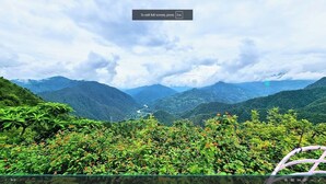 A scenic view of a mountainous landscape with lush greenery and a river. - Emerald Woods Mukteshwar (Dhari)