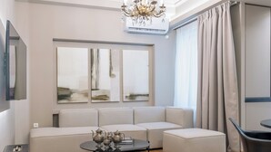 A modern living room with a sofa, a coffee table, and a TV. - Urban Elegance in Kolonaki 7min walk to Syntagma (Athina)