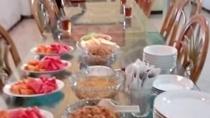 A long dining table with various dishes and bowls of food, surrounded by chairs. - Wisma Shalom  (Jakarta)