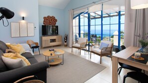 A modern living room with a sofa, coffee table, and TV. There is a balcony with a view of the ocean. - Ático Galera Playa Free Padel by Interhome (Almuñécar)