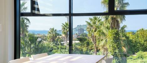 A room with a large window offering a view of palm trees and a cityscape.