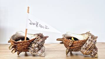 Two seashells with a small white flag and Korean text.