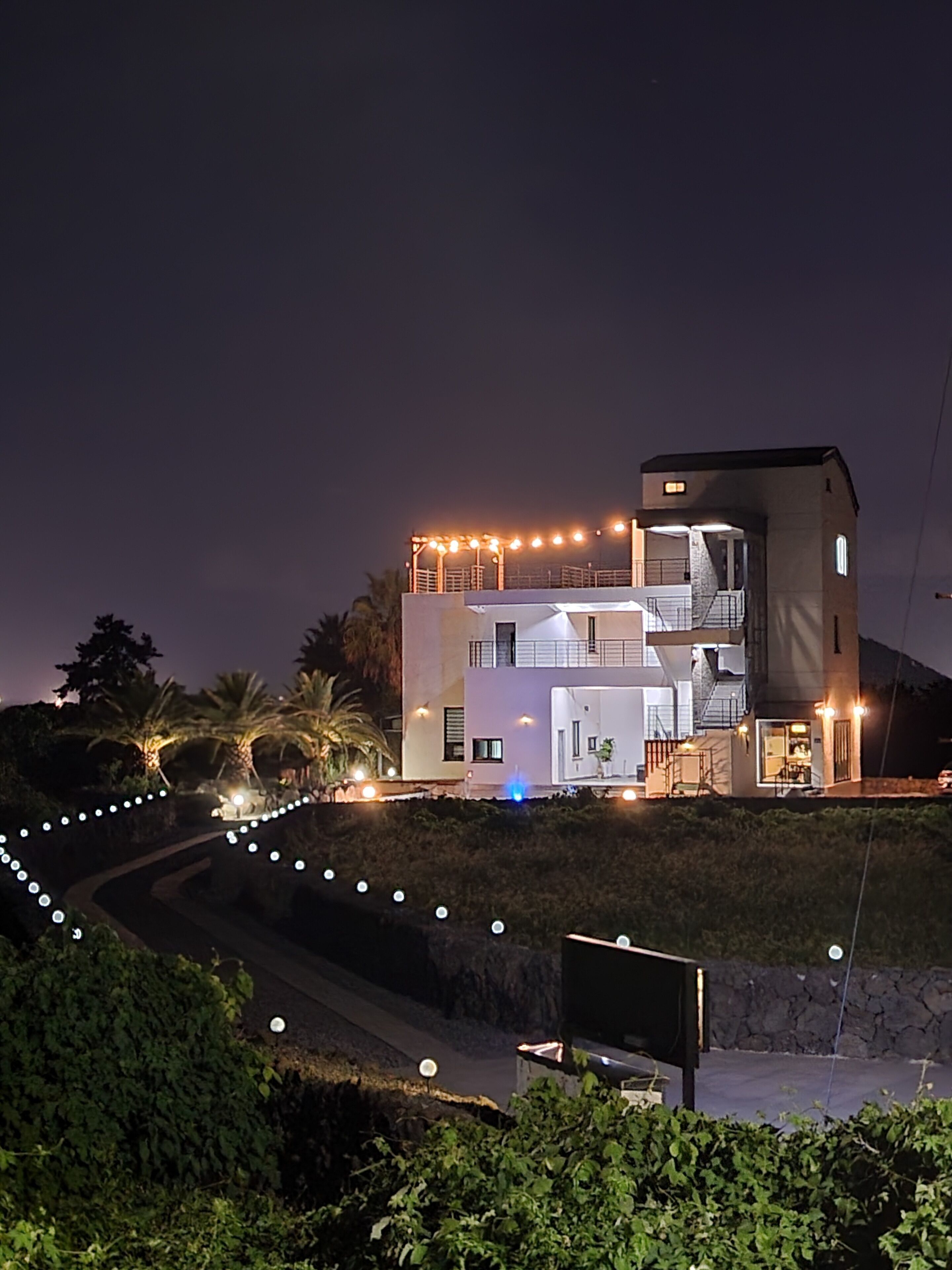 A modern two-story house with a balcony and a staircase leading to the upper level.