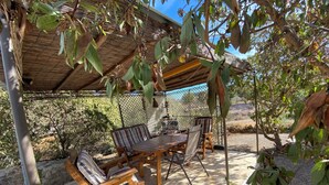 An outdoor patio with a table and chairs, a pergola, and a view of the surrounding landscape. - Tolles Ferienhaus in Südspanien, in Ruhiger Natur zum Entspannen und Wandern (Águilas)