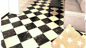 A living room with a black and white checkered floor, a flat-screen TV mounted on the wall, a ceiling fan, and a sofa. - Cozy 2-bedroom apartment with WiFi, air-con and a  rooftop terrace with bbq. (LLUCMAJOR)