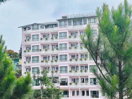 Un hotel de varios pisos con balcones, cada uno decorado con plantas en macetas.